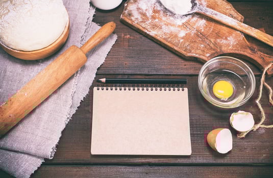 paper notepad with black pencil and dough with ingredients photo