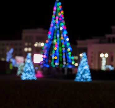 blurred background with a Christmas tree on a city square photo