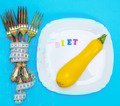 yellow squash on a white ceramic plate, next to a pile of iron forks photo