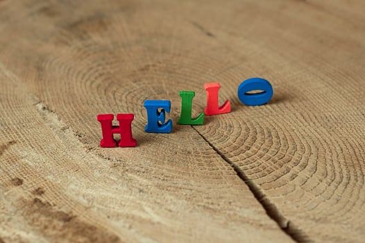 word hello from small wooden letters on a stump photo