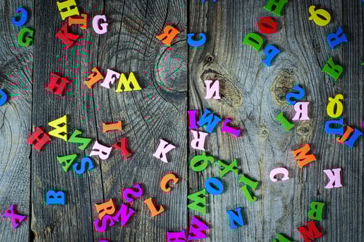 Multicolored little wooden letters on a gray surface photo