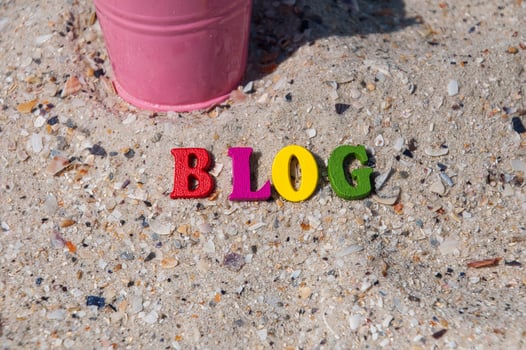 Multicolored wooden letters on the sand photo