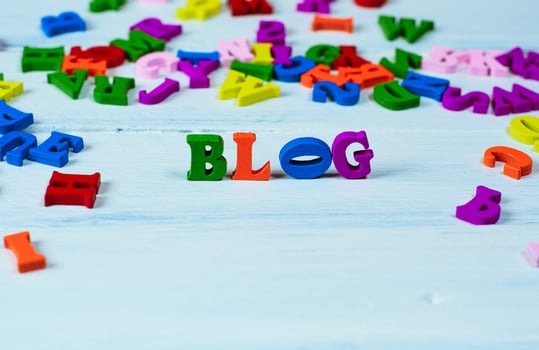 Word blog from small multicolored wooden letters on a white surface photo