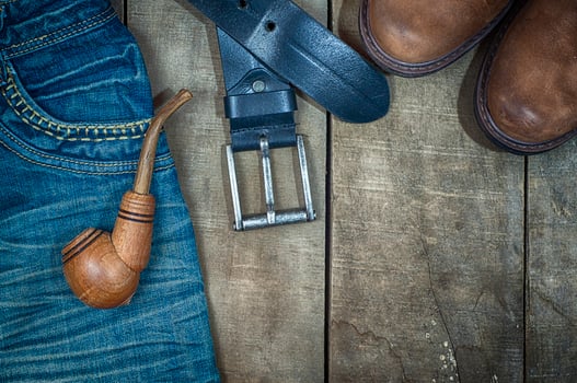 Detail of worn blue jeans and brown shoes on a wooden background photo