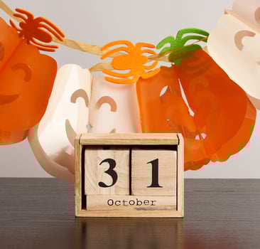 wooden calendar of cubes with the date October 31, garland of pumpkins and spiders, celebration of Halloween photo