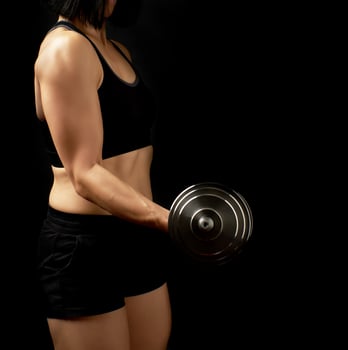 young woman of Caucasian appearance holds steel type-setting dumbbells in her hands photo