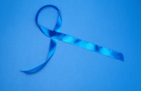 blue silk thin ribbon twisted on a blue background photo