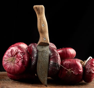 round red onion in husk on a gray linen napkin, black background photo