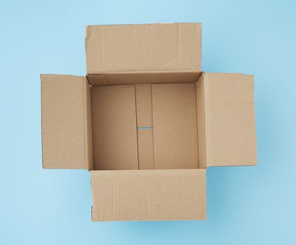open square empty cardboard brown box for packing and shipping things on a blue background photo