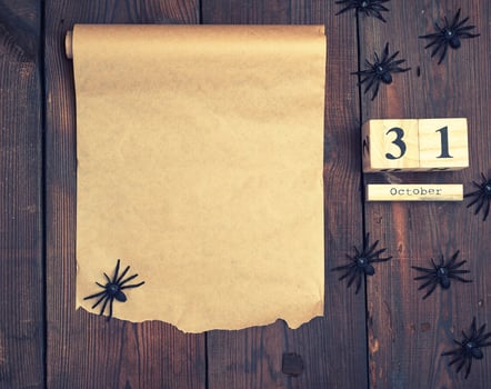 black spider figurines and wooden retro clock made of blocks with the date of October 31 photo