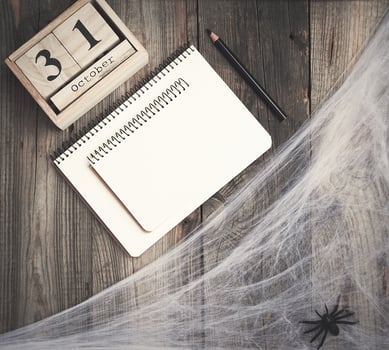 black spider figurines and wooden retro clock made of blocks with the date of October 31 photo