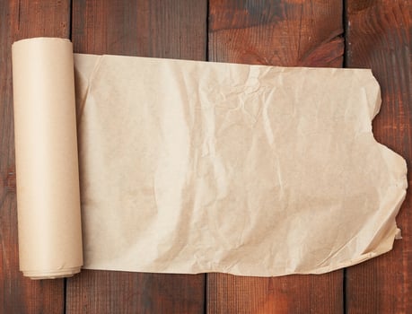 roll of untwisted brown paper on a wooden surface from old boards photo