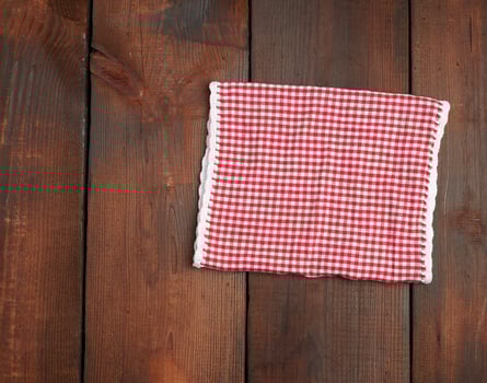 white red checkered kitchen towel on a brown wooden background photo