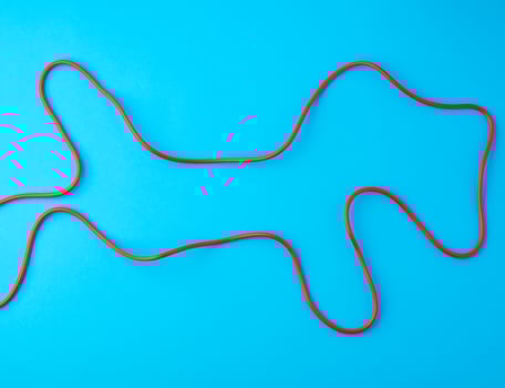 fragment of a red jump rope for sports on a blue background photo