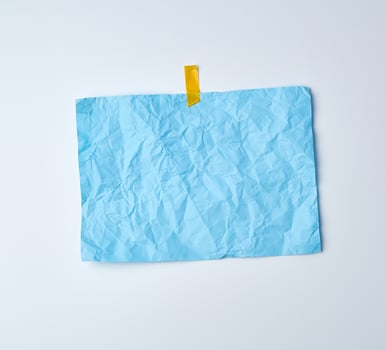 blue crumpled sheet of paper glued with adhesive tape photo