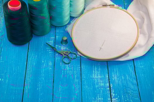 Some turquoise thread with the fabric in the wooden embroidery frame for needlework photo