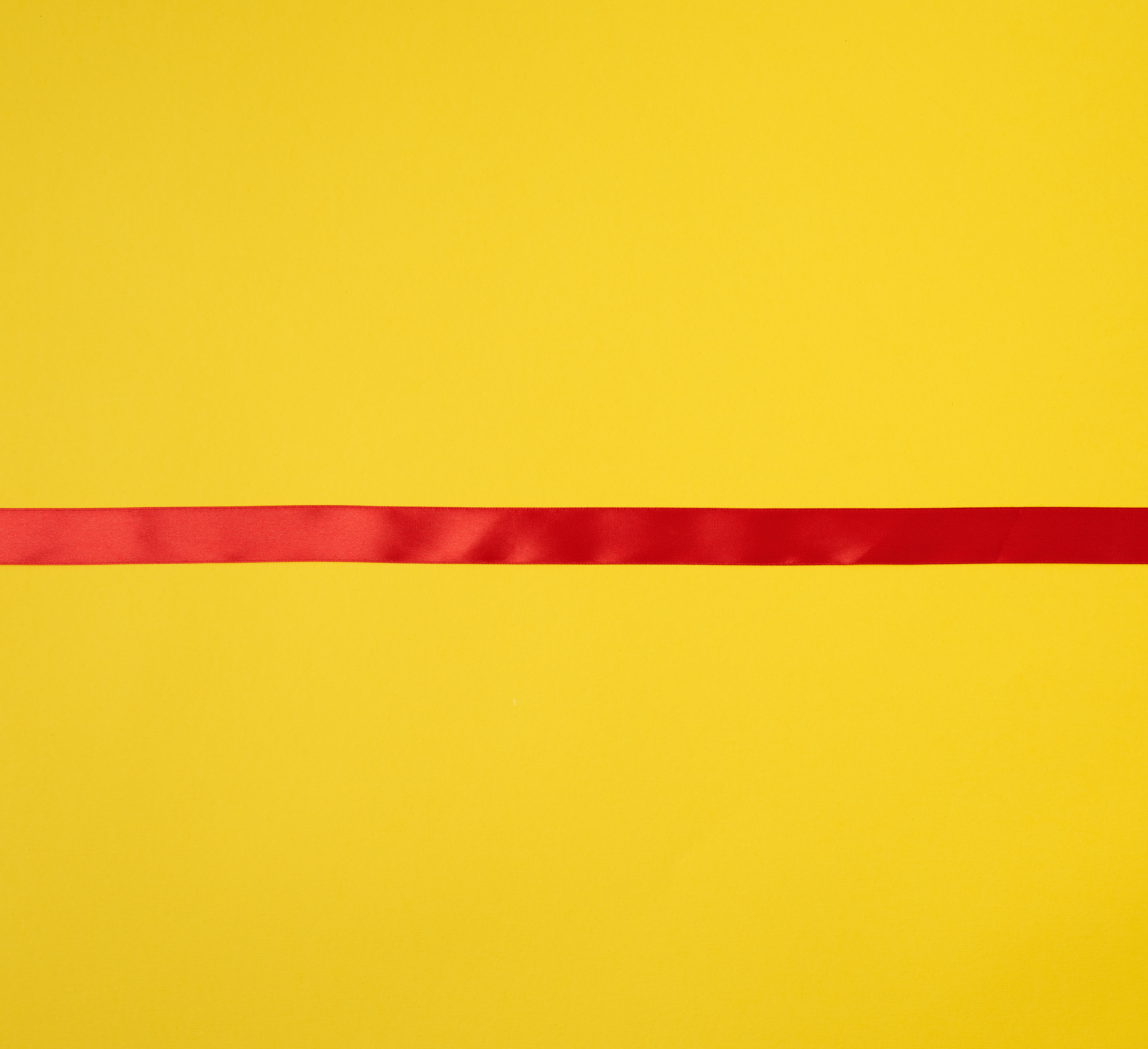red silk ribbon on a yellow background, festive backdrop photo