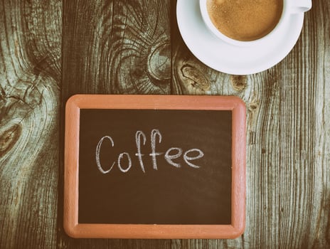 Black chalk board on a gray surface, inscription in chalk coffee photo