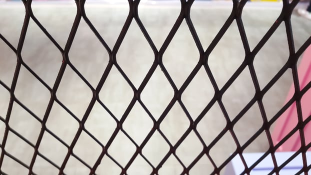 Wire mesh fence with blurred background of concrete floor photo