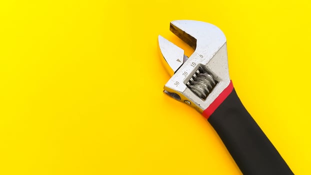 Adjustable spanner or adjustable wrench isolated on yellow background photo