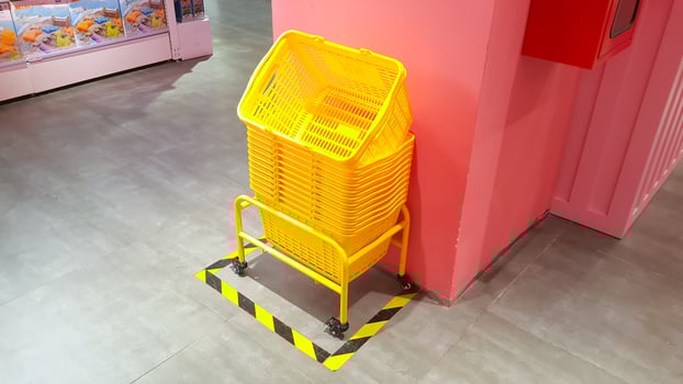 Pile of yellow plastic shopping baskets on the floor photo