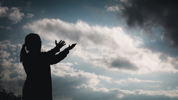 Christ religion and christianity worship or pray concept.Silhouette of Christian catholic woman are praying to god in dark sky. Prayer person hand in nature background. Girl believe and faith in jesus photo
