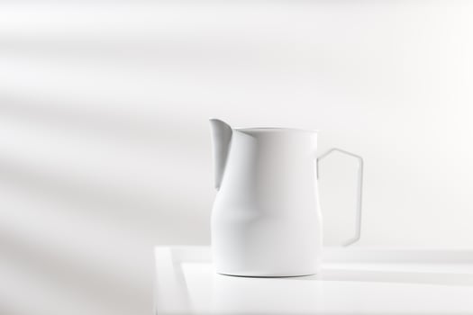 White pitcher on white wooden table in minimalist style. photo