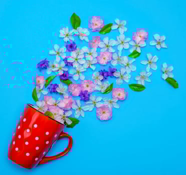of red ceramic mug with white polka dots randomly poured flower photo