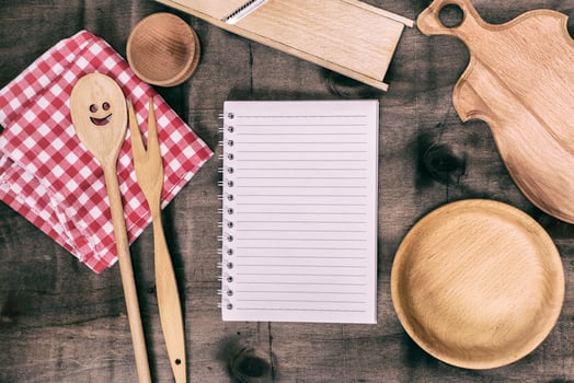 open notepad with wooden kitchen objects photo