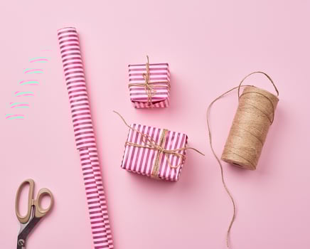 skein with a brown rope, roll with holiday wrapping paper, scissors photo