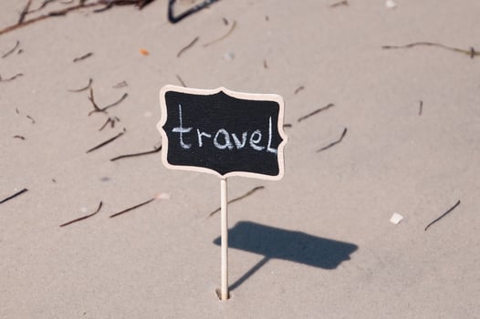 Black wooden board with inscription travel on the seashore photo