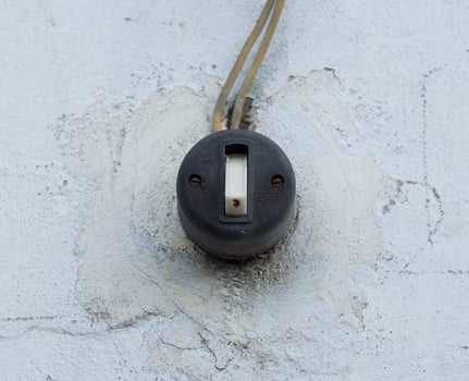 Old vintage light switch on white wall photo