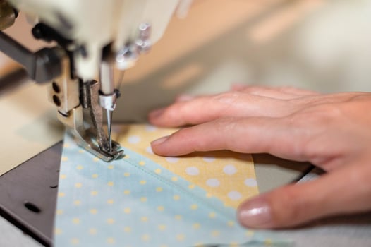 Closeup the female hand use sewing machine and cotton fabric at the old sewing machine with vintage style. photo
