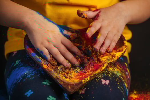 children's hands hold a wooden plate in the shape of a heart in which the multi-colored bright colors of Holi. Indian festival of colors Holi. photo