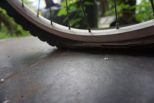 flat bicycle tire in front of the house in the morning photo