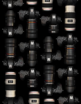 Mirrorless Cameras with different lenses for shooting videos. Top view of digital cameras isolated on black background photo