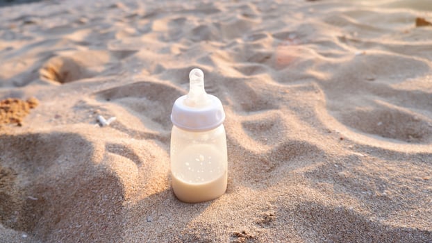 Milk bottle on the beach sand at sunset photo