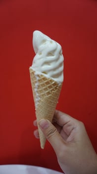 A hand holding a cone of ice cream photo