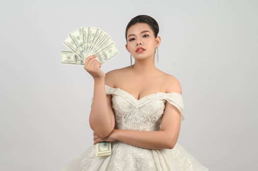 Young asian beautiful bride holding dollar bills in hand photo