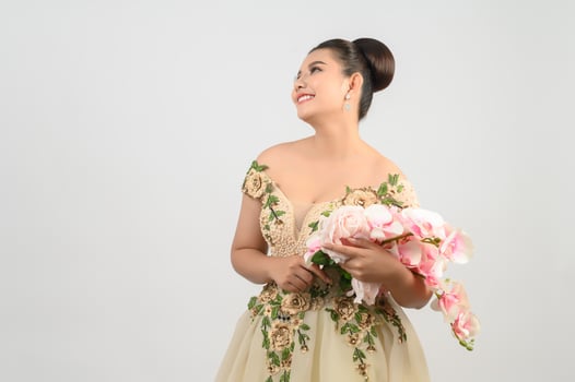 Young asian beautiful bride with orchid bouquet on white background photo