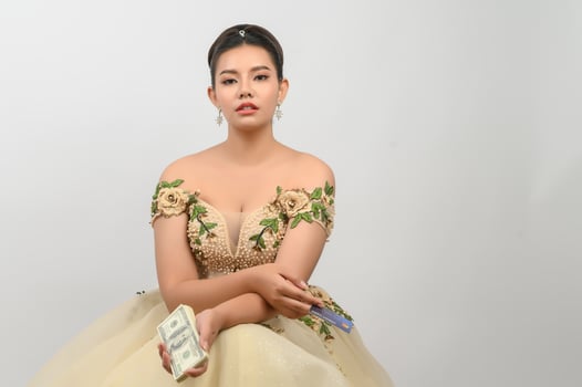 Young asian beautiful bride holding dollar bills and credit card in hand photo