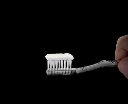 Hand hold toothbrush on black background. dental care symbol concept photo