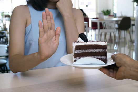 One of the health-care girls used a hand to push a plate of chocolate cake. Refuse to eat foods that contain Trans Fat. photo