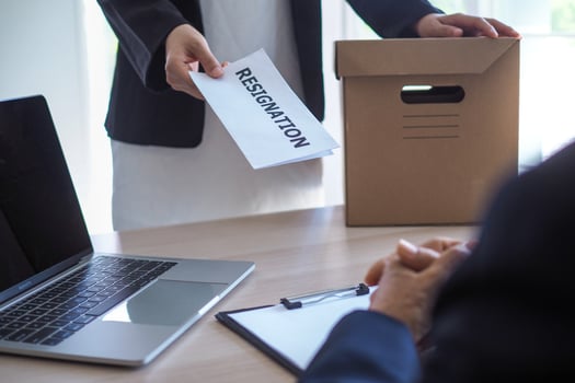 The business woman has a brown cardboard box next to her body and sends a letter of resignation to the executive. Include about resignation, job placement and vacancies. photo