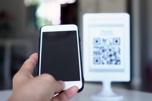 Hands use the phone to scan QR codes to receive discounts on purchases. photo