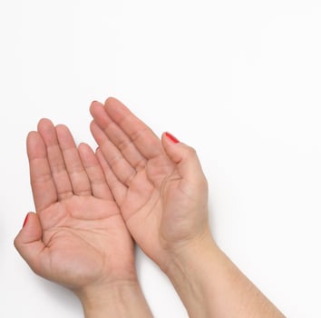 two female hands with red painted nails in a prayer pose on a white background photo