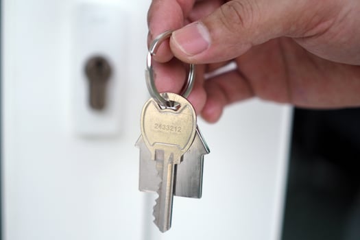 The hand of the banker holds the house key. Home and land mortgage concept photo