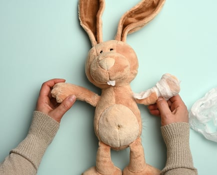 soft plush rabbit with a bandaged paw with a white medical bandage photo