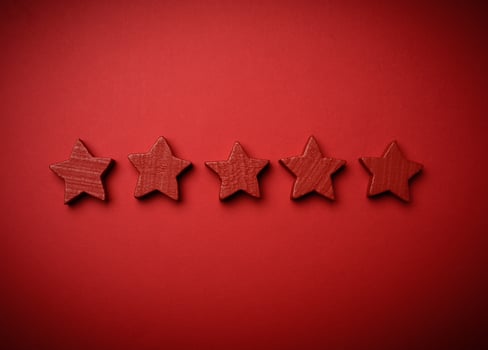 five red wooden stars on a red background photo
