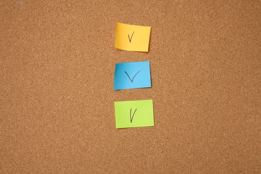 colorful paper stickers glued to brown cork board photo